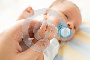 toned image of newborn baby holding fathers hand. Photo with soft focus