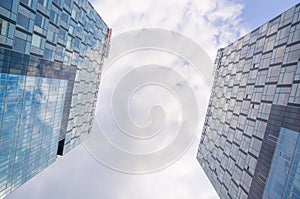Toned image of two modern office buildings, underside view