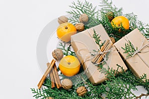 Toned instagram image wrapping rustic eco Christmas gifts with craft paper, string, tangerines and natural cypress branches on