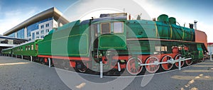 Toned panoramic image of vintage steam locomotive at railroad station