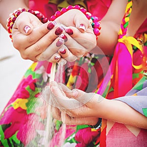 Toned photo of Falling sand from woman hand in a