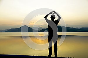 Toned Photo of Hands in Heart Shape on Sky Background