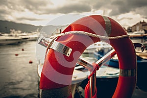 Toned photo of lifebuoy at rainy weather in seaport