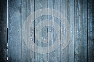 Toned photo of an old fence made of nailed boards. Dark blue background for sites and layouts with vignette