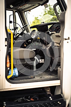 Toned photo two steering wheels for dual control on modern four wheel mechanical broom sweeper truck, cabin complete
