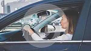 Toned portrait of beautiful female driver driving a car in city