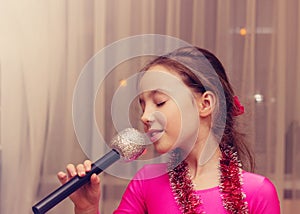 Toned portrait of cute little girl singing into a microphone