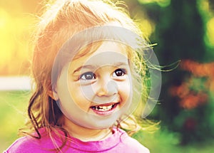 Toned portrait of Cute little girl smiling in sunny summer day