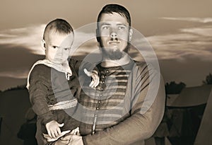 Toned portrait of a Slavic man with a baby in historical costume