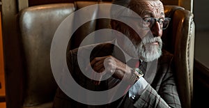 Toned retro styled portrait of businessman sitting in armchair at office