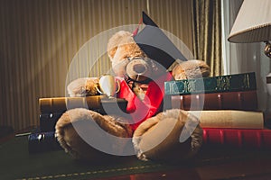 Toned shot of teddy bear in graduation cap sitting at library