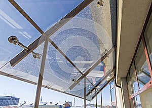 Toned transparent roof with broken glass panel.