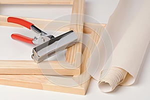 Tongs, canvas and wooden stretchers for stretching canvas on a white background
