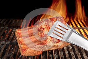 Tongs Holding Grilled Pork Ribs