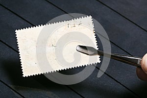 tongs keeps postage stamp with unused back side