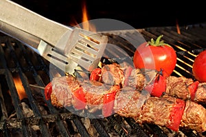 Tongue Hold BBQ Beef Shish Kebab With Vegetables On The Hot Fla