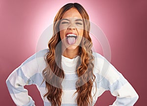 Tongue out, silly and face of woman in studio for crazy, goofy and funny expression isolated on red background