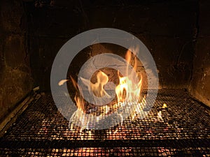 Tongues of fire pass through the grill net at night