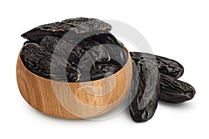 Tonka bean in wooden bowl isolated on white background with clipping path and full depth of field. Bean of Dipteryx