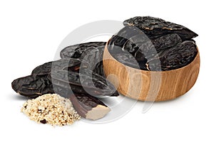 Tonka bean in wooden bowl isolated on white background with clipping path and full depth of field. Bean of Dipteryx