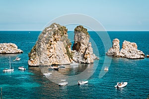 Tonnara di Scopello in Sicily, Italy. Boats with tourists floating near the cliffs