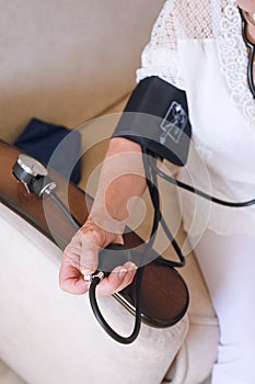 Tonometer for non-invasive measurement of blood pressure on the arm of elderly woman