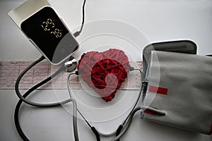 Tonometer,stethoscope and artificial red heart on a white background.
