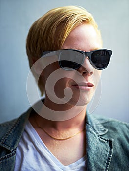 Too cool. Portrait of an attractive young guy wearing hipster shades.