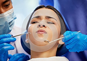 Is it too late to change my mind. a young woman experiencing anxiety while having a dental procedure performed on her.