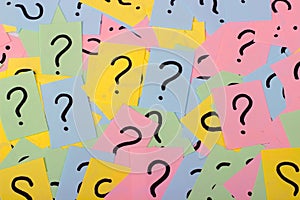 Too Many Questions. Pile of colorful paper notes with question marks. Closeup