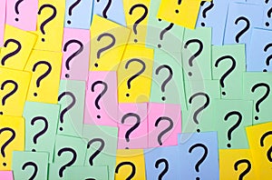 Too Many Questions. Pile of colorful paper notes with question marks. Closeup