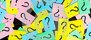 Too Many Questions on wooden background. Pile of colorful paper notes with question marks. top view