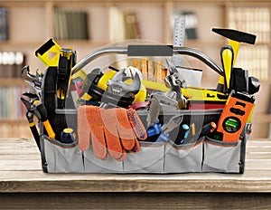 Tool belt with tools on wooden background