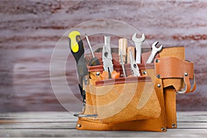 Tool belt with tools on wooden background