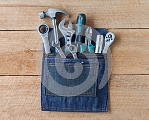 Tool belt with tools on wooden board background