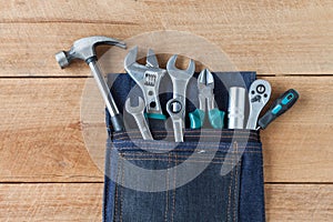 Tool belt with tools on wooden board background