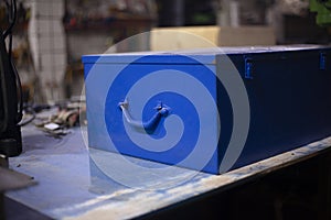 Tool box in blue. An old box lies on the table. Vintage object in the garage