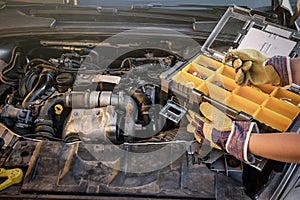 Tool box with hand on car engine close up