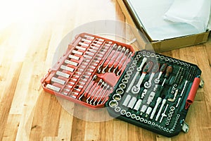 Tool box,set of bits and wrenches on laminated floor.