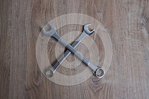 Tool crossed spanners on a wooden background.