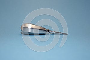 Tool of dentist for teeth removal on blue background