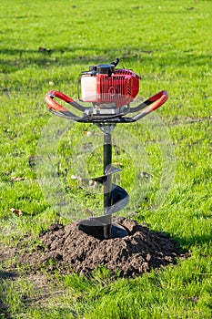 Tool hand-held soil hole drilling machine or portable manual earth auger for prepare the soil for planting shrubs or trees in