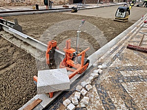 tool for laying interlocking paving. Continuously adjustable consisting of