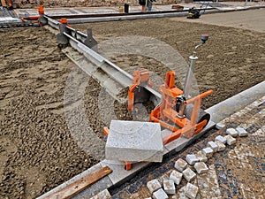 tool for laying interlocking paving. Continuously adjustable consisting of