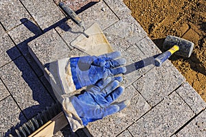 Tool for laying paving slabs on a background of granite bricks a