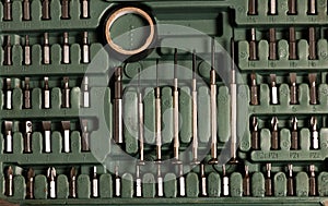 Tool set of screwdriver bits with different nozzles stowed in a