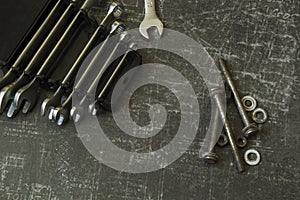 Tool set of wrenches, bolts and nuts on abstract grey surface
