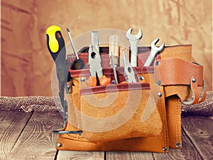 Tool belt with tools on wooden background