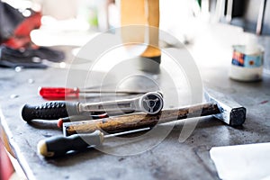 Tool on workbench in auto repair shop. Mechanics repairing, maintaining car in garage, photo