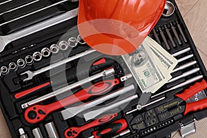 Toolbox, tools kit detail, dollar bills and orange protective helmet close up. instruments. set of tools. car tool kit. tool set